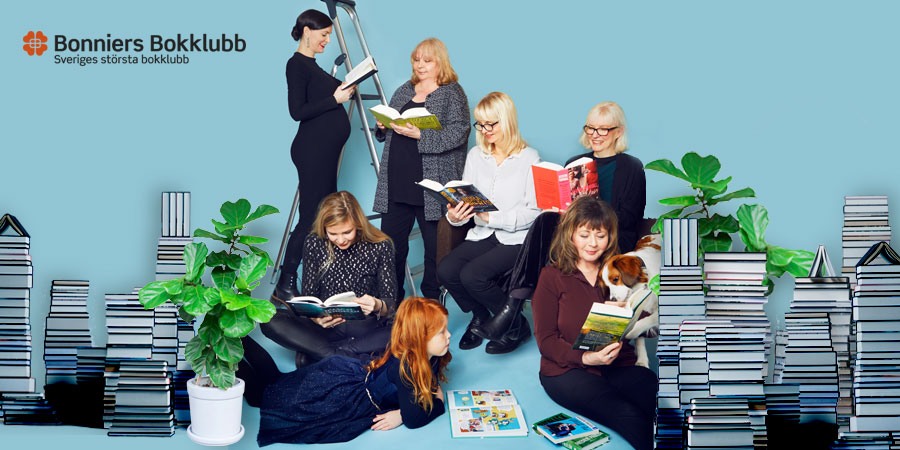 En grupp människor står och sitter bland bokhögar