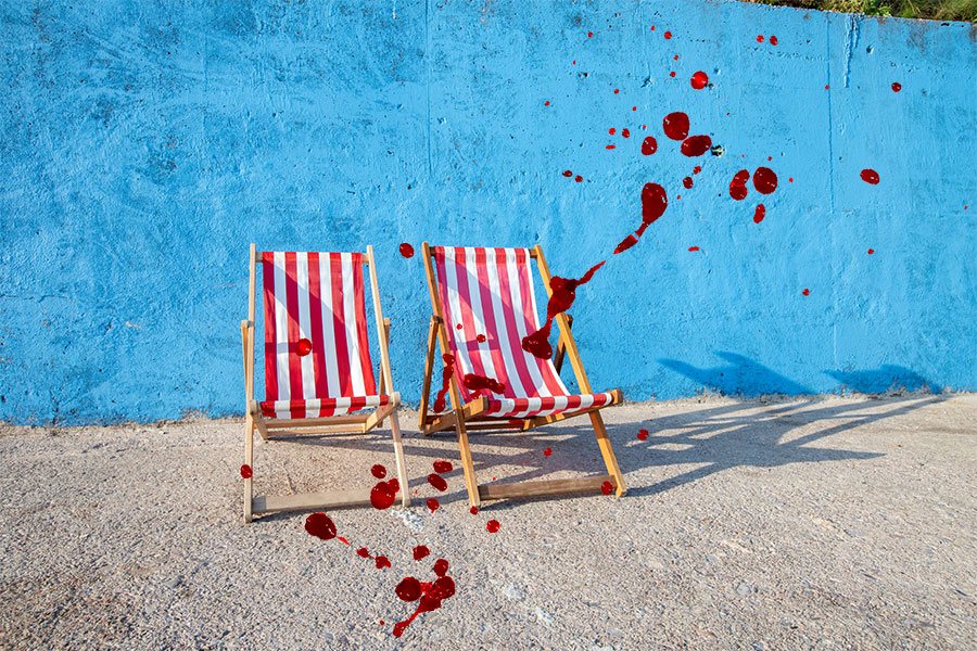 Två solstolar med blodfläckar över.